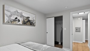 A bedroom with a bed, a wardrobe, and a door leading to a closet. - King Bed-Stadium District Getaway (Tacoma)