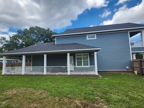 A two-story house with a covered porch and a fenced backyard. - Black-Water River Retreat! to this Luxurious 3-bedroom 3.5 bath house (Milton)