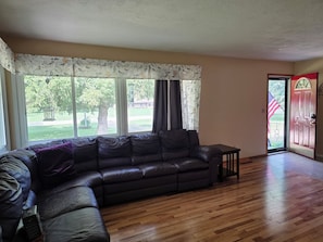 Una sala de estar con un sofá modular, una mesita y una puerta que da al exterior.