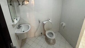 Un baño pequeño y limpio con inodoro, lavamanos y espejo.