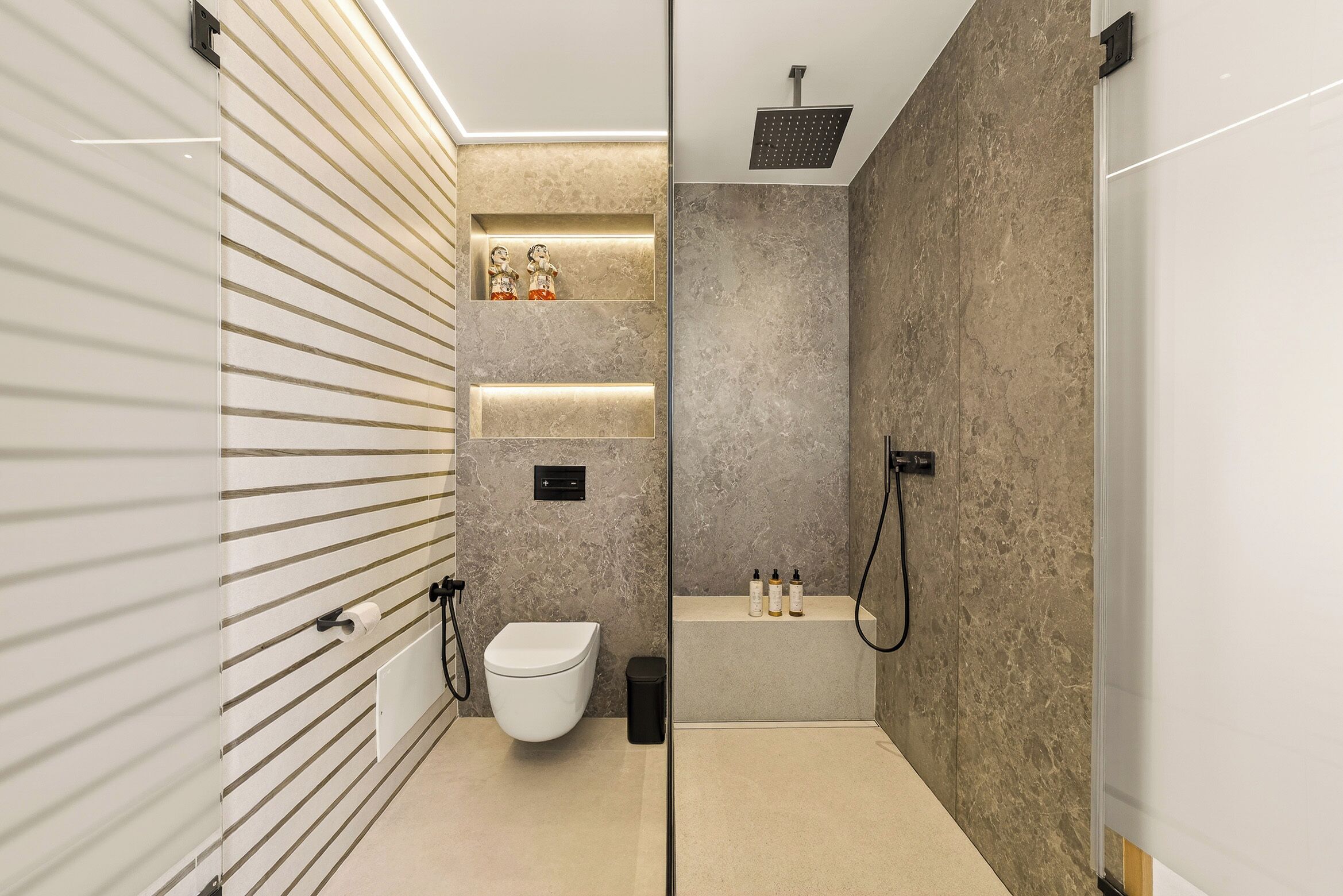 Un baño moderno con inodoro, bidé y ducha.