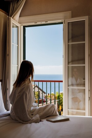 A person sitting by a window with a view of the sea. - Cais 68 Luxury Boutique Villa - Adults Only - 24h Concierge (Funchal)