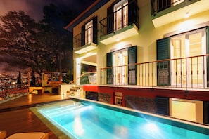 A poolside view of a hotel with a pool, outdoor seating, and a balcony with railings. - Cais 68 Luxury Boutique Villa - Adults Only - 24h Concierge (Funchal)
