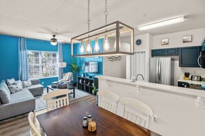 A modern kitchen with a white countertop, a built-in oven, and a stainless steel refrigerator. - Cozy 2-bedroom Condo with AC near Disney (Kissimmee)