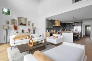 Un salon moderne comprenant un canapé, une table basse et un coin cuisine avec un ensemble de salle à manger.