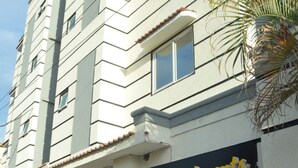 A multi-story building with a sign for 'Apartments' and a palm tree in front. - Edinah Homes in Shanzu,Mombasa,Kenya,the beach 5 minute (Mombasa)