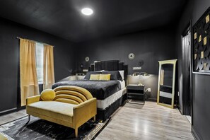 A modern bedroom with a bed, bedside tables, a wardrobe, and a chair.