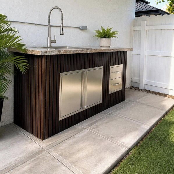 An outdoor kitchen with a sink, a built-in cabinet, and a potted plant. - STUDIO Aprt Fort Lauderdale Top Location (Fort Lauderdale)