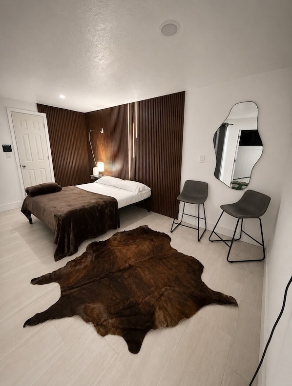 Une chambre avec deux lits, un grand miroir et un tapis en cuir.