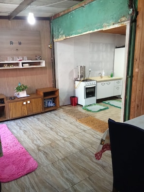 Eine kleine Küche mit Herd, Backofen und Mixer auf der Arbeitsfläche.