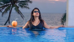 A person in a swimming pool with a drink and a tropical background. - Dutch Point Beach Resort - Negombo (Negombo)