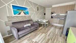 Una cucina moderna con forno a microonde, fornelli e pensili verdi.