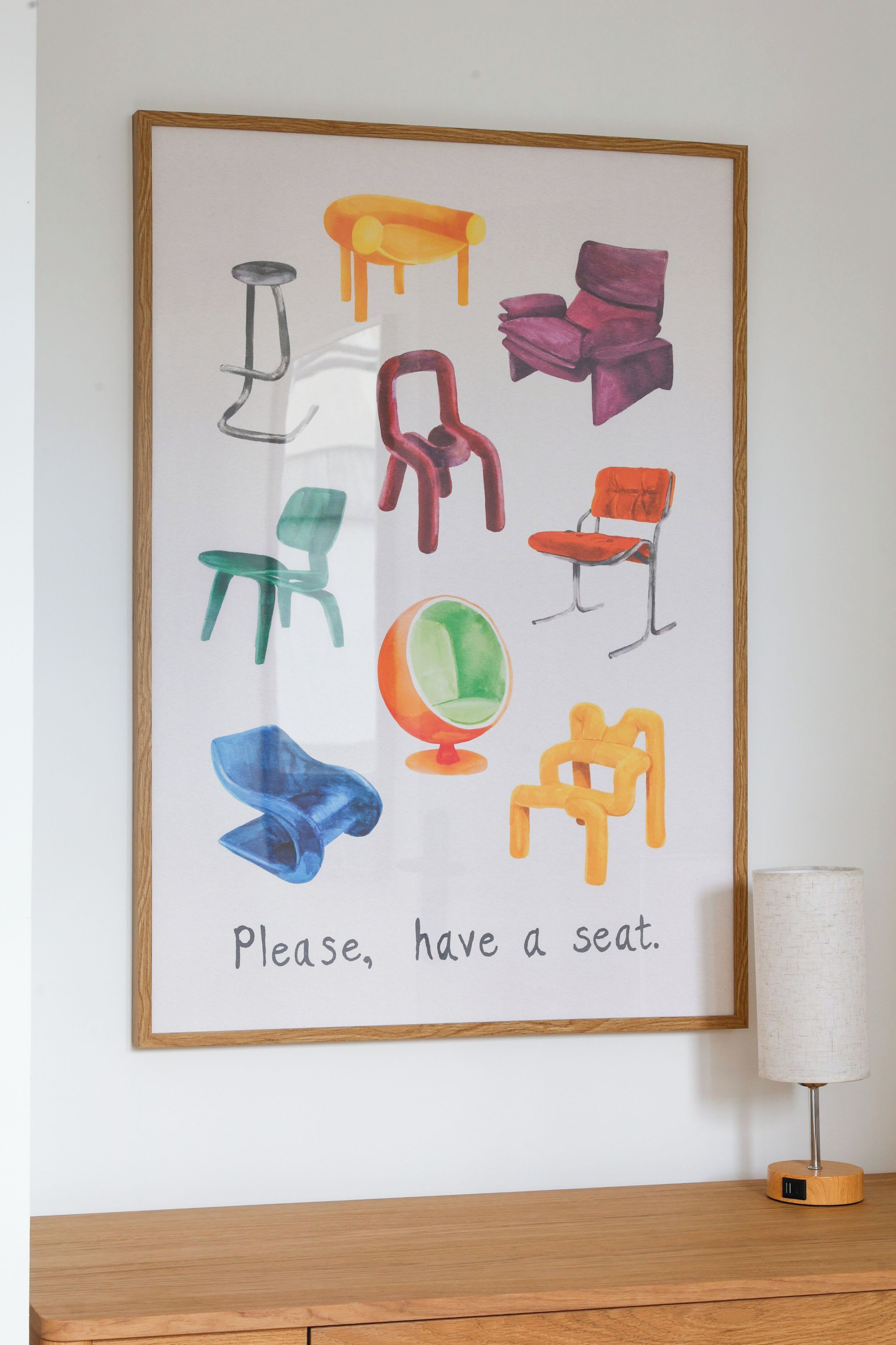Une œuvre d’art encadrée représentant différentes chaises, avec le texte : « Veuillez prendre place. »