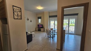 Een moderne woonkamer met een televisie, een eethoek en een balkon met uitzicht.