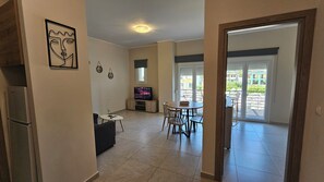 Ein modernes Wohnzimmer mit Fernseher, Essbereich und einem Balkon mit Blick.