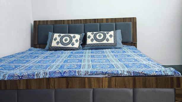 A bed with a patterned bedspread, two pillows with a geometric design, and a headboard. - 2kms  to hawamahal homestay in jaipur (Jaipur)