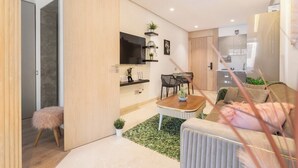 Un saló modern amb un sofà, una taula de centre, una televisió i una zona de menjador.