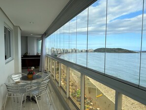 Un balcon avec vue sur la plage et le paysage urbain.