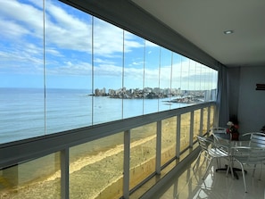 Un balcon avec vue sur la plage et le panorama de la ville.