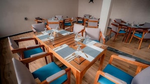 A conference room with wooden tables and chairs, arranged for meetings.