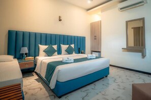 A hotel room with a large bed, a nightstand, a lamp, a wardrobe, and a mirror. - Sea La Vie Hotel Negombo (Negombo)