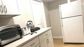 A kitchen with white cabinets, a microwave, a kettle, and a refrigerator. - Basement Queen Bedroom-E（Private Room，Shared Bathroom） (Greater Sudbury)