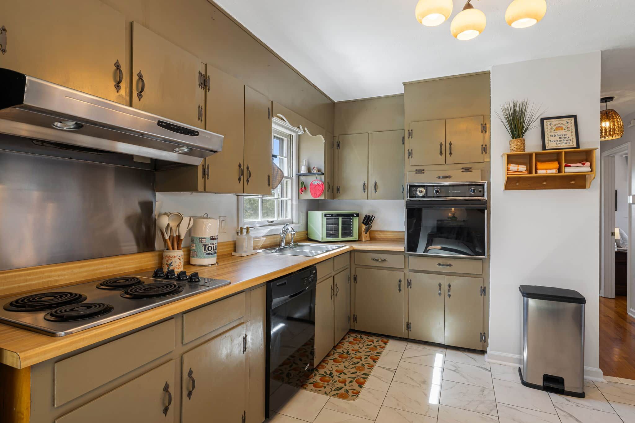A kitchen with a stove, oven, microwave, and dishwasher.