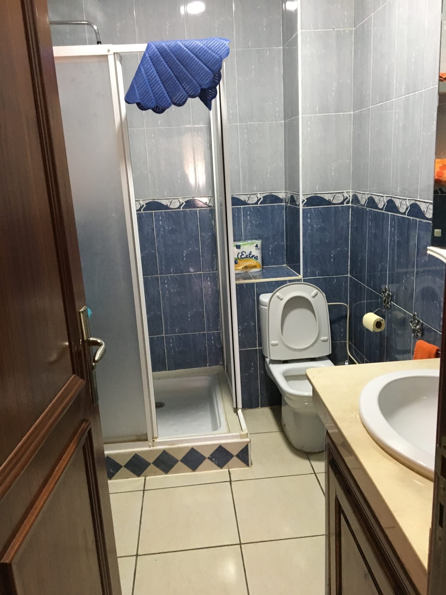 Et badeværelse med brusebad, toilet og håndvask.