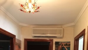 Un pasillo con ventilador de techo, equipo de aire acondicionado y un cuadro en la pared.
