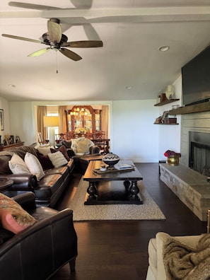 A living room with a dark wood coffee table, leather sofa, and a fireplace.