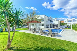 A modern house with a swimming pool, sun loungers, and a well-maintained lawn. - Magical Villa ,between old town; Split - Trogir , with heated pool and jacuzzi. (Kaštel Štafilić)