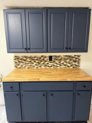 A kitchen with dark blue cabinets, a wooden countertop, and a mosaic tile backsplash. - Charming 3-bedroom apartment with AC in Naples (Naples)