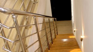 A staircase with metal railings and wooden steps, leading to a dark room. - Peaceful 3-bedroom building with AC in vibrant Accra (Accra)