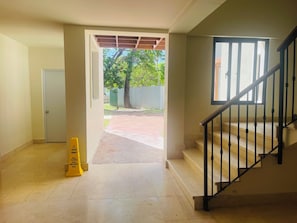 Un couloir menant à un escalier qui donne sur une cour arrière.