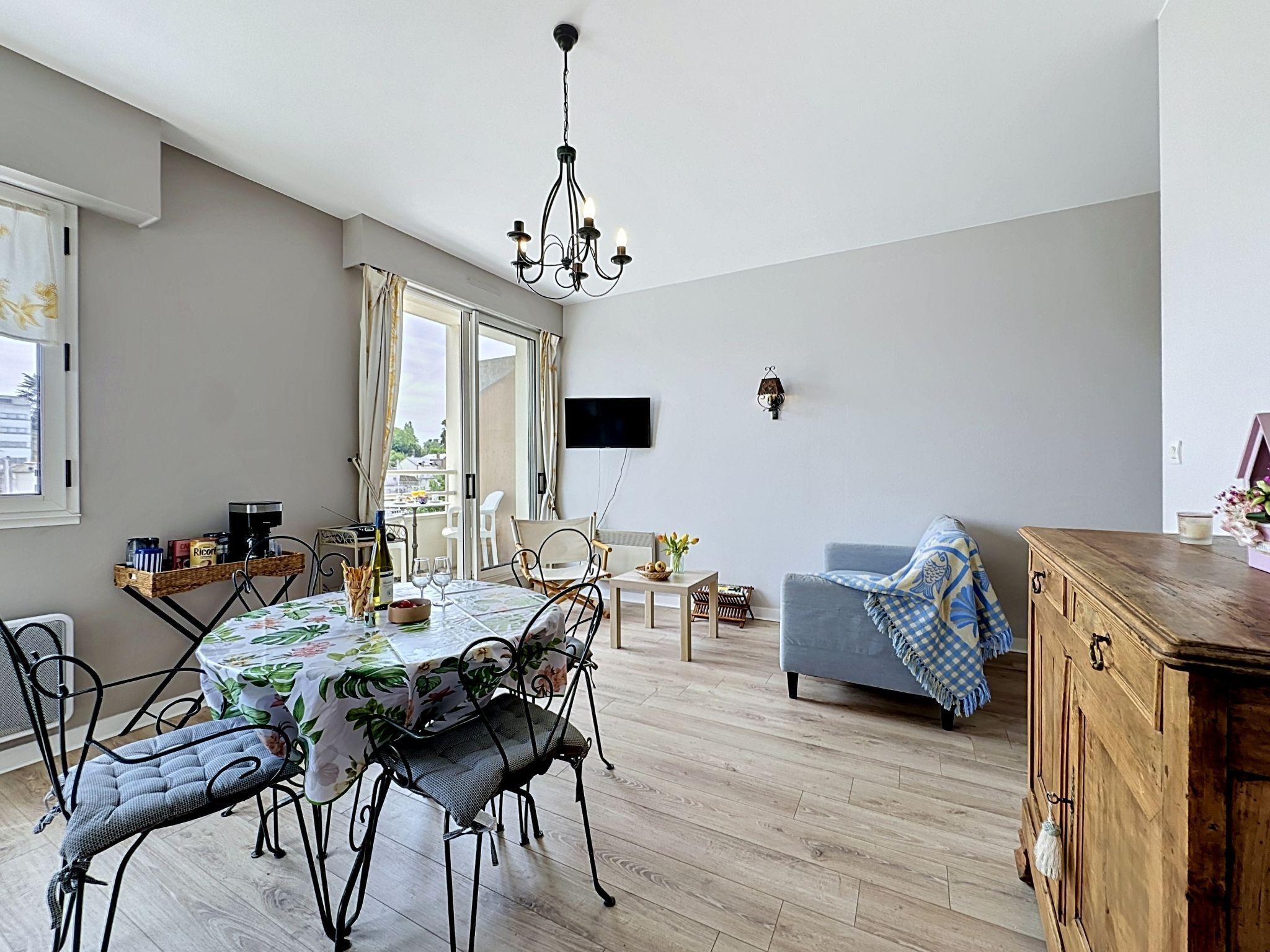 A dining area with a table, chairs, and a chandelier.