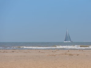 Ein Segelboot auf ruhiger See unter wolkenlosem Himmel.