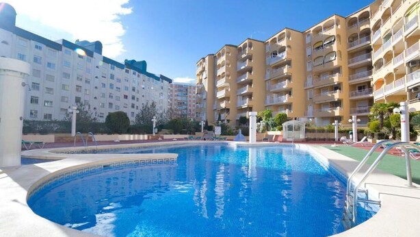 Une piscine entourée d’immeubles résidentiels à plusieurs étages, dotés de balcons.