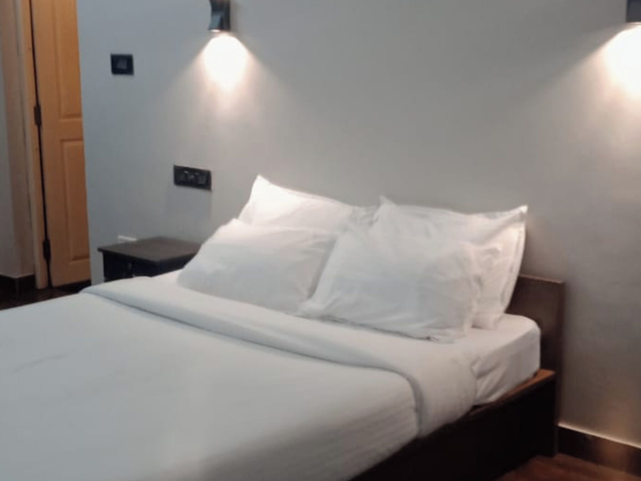 Ein ordentlich bezogenes Bett mit weißen Leinen in einem Hotelzimmer.