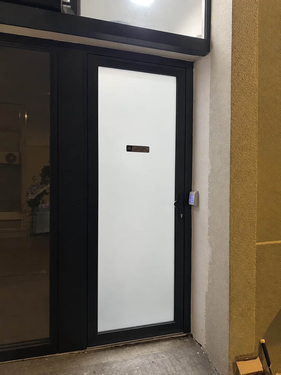 A closed door with a black frame and a small plate in the center.