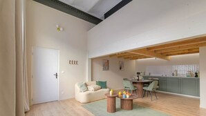 Een modern appartement met een eethoek, keuken en woonkamer met een bank en salontafel.