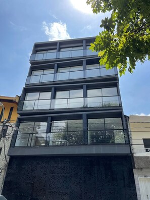 Een meerhoog gebouw met grote ramen en een metalen gevel.