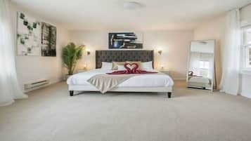 A bedroom with a bed, bedside tables, a mirror, and artwork on the walls.