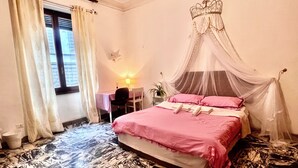 A bedroom with a bed, a desk, a chair, a window, and a curtain.