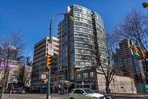 A multi-story building with a modern architectural design, featuring a curved facade and large windows. - 2 Bed 2 Bath Free Parking Downtown Vancouver (Vancouver)