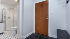 A bathroom with a shower, toilet, and a wooden door. - 2 Bed 2 Bath Free Parking Downtown Vancouver (Vancouver)