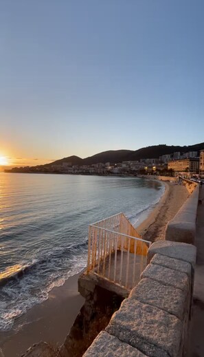 A coastal cityscape with a beach, a stone sea wall, and buildings in the background. - Bright T2 apartment with sea view, Center of Ajaccio (Classified 1 *) (Ajaccio)