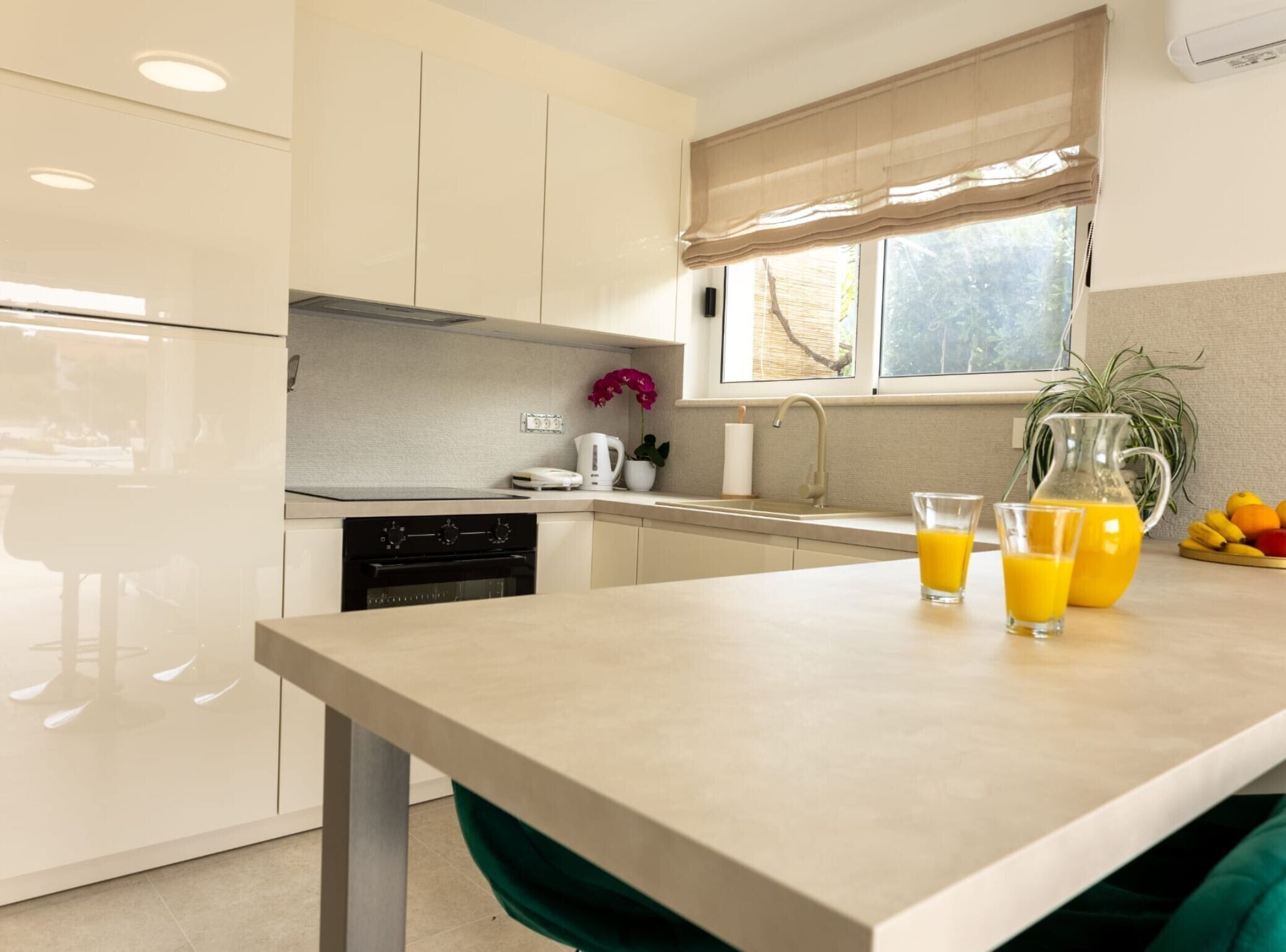 A modern kitchen with a dishwasher, oven, and a window with a view of the outdoors.