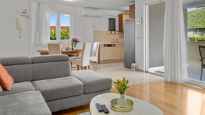 Een modern appartement met een woonkamer, eetgedeelte, keuken en een balkon met uitzicht.