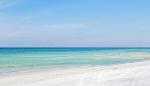 Una platja amb aigua turquesa cristal·lina i una riba sorrenca.