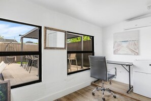 A room with a desk, chair, and large windows. - Pool + Hot Tub | Outdoor Kitchen | Hollywood FL (Hollywood)